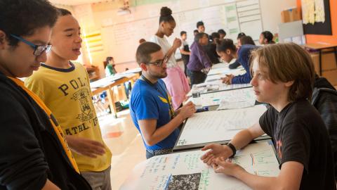 Multicultural group of middle school students sharing project based learning