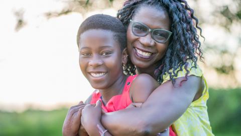Black mother hugging her adolescent son