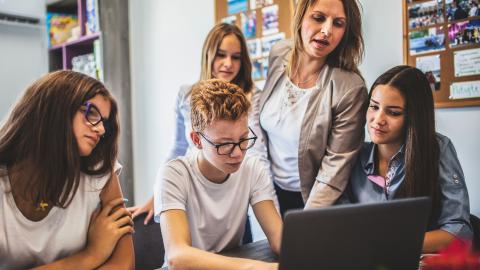 Teacher offers writing instruction to group of high school students 