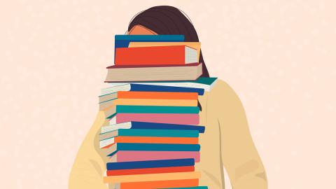 Adolescent holding a stack of books that are as high as the top of her head.