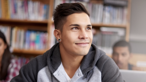 Adolescent Boy looks up from his book and notebook