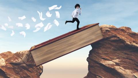 Teen boy running across a book wedged between two mountain tops