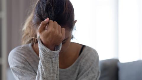 Teen girl looking down into her hand while sitting