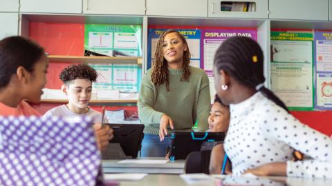 Math teacher working with four students in her classroom