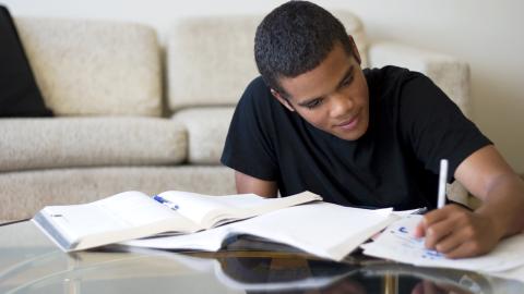 16 year old boy working on his writing homework