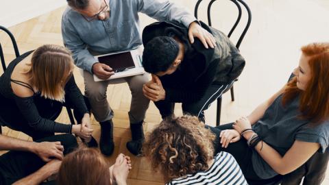 Teachers sitting in a circle comforting one another