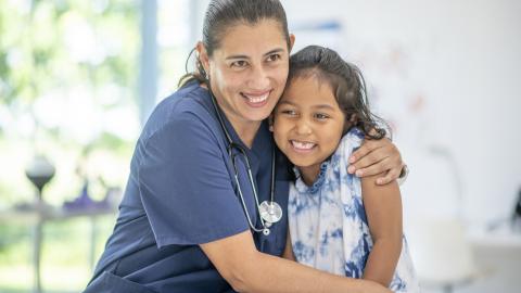 School nurse giving a young girl a young of reassurance