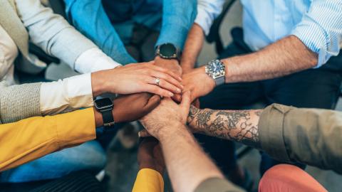 multi ethnic team holding their hands together. 