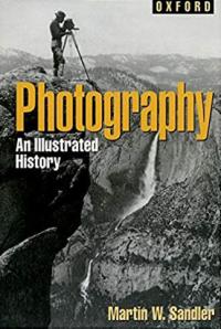 Photographer with view camera capturing dramatic canyon landscape