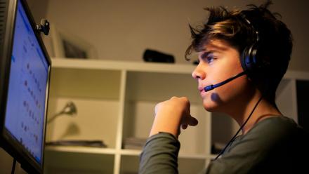 middle school student using assistive technology with headphones