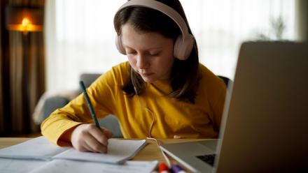Middle grade female student using assistive technology at home
