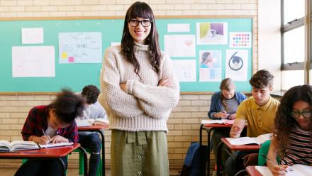 Asian-American middle school English teacher in front of multicultural class