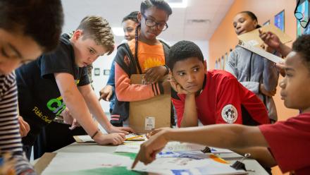 Multicultural group of middle school students sharing project based learning