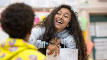 Latina high school student talking with classmate