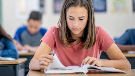 Young teen girl working on reading fluency in class