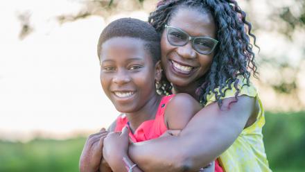 Black mother hugging her adolescent son