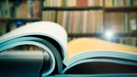 stack of open journals in a library