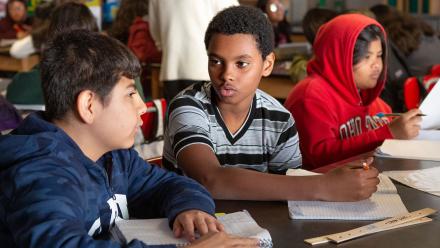 Multicultural middle school students discussing a text