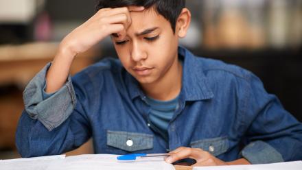 Latino middle grade student reading text in class