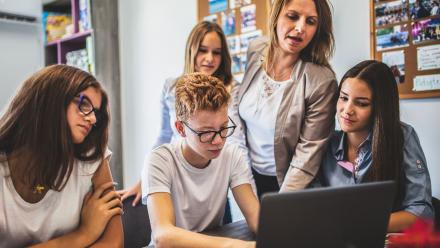 Teacher offers writing instruction to group of high school students 