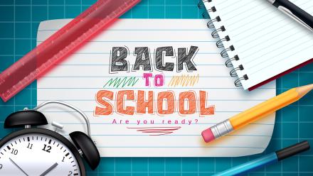 Back to School written on a notecard with a ruler, pencil, and alarm clock 