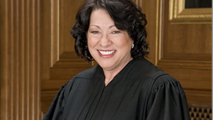 Justice Sotomayor smiling to the camera dressed in her robes