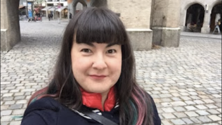 Mariko Tamaki in a selfie in Germany; standing in front of an archway
