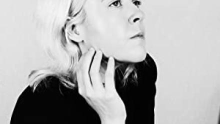 headshot of Courtney Summers in a black shirt looking away from the camera