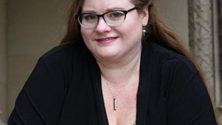 Head shot of Beth Revis wearing a black sweater and arms lightly crossed.