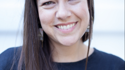 head shot of nina lacour wearing a navy shirt and smiling towards the camera