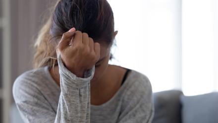 Teen girl looking down into her hand while sitting