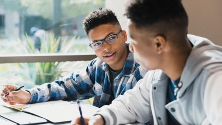 Two boys writing beside one another