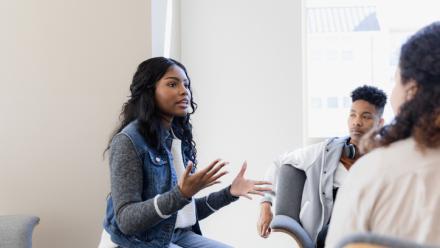 Young woman explaining her ideas to a group.