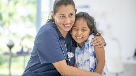 School nurse giving a young girl a young of reassurance