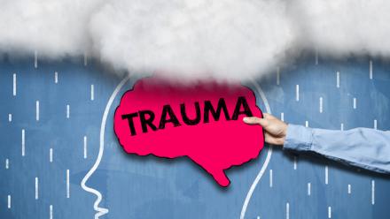 Outline of a head with clouds above it and a hot pink brain with the word TRAUMA written across it
