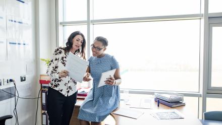 Two teachers conference at an egg shaped table