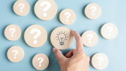 wooden circles with question marks and one with a lightbulb indicating an idea