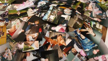 family photographs unorganized and sprawled across a table
