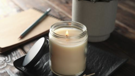 A lit candle and journal laying on a table 