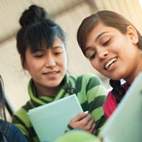 Three high school ELL students looking at book