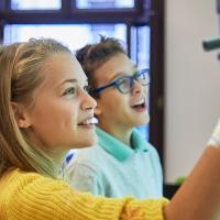 Two middle school students working at white board