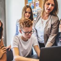 Teacher offers writing instruction to group of high school students 