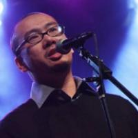 Bao Phi in a night club at the microphone speaking