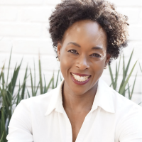 Margot smiling to the camera wearing a white button down shirt