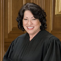 Justice Sotomayor smiling to the camera dressed in her robes