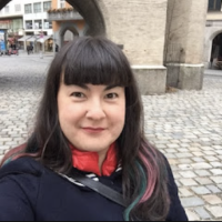 Mariko Tamaki in a selfie in Germany; standing in front of an archway