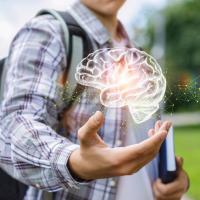 adolescent boy walking with his backpack on and an image of a brain in his hand