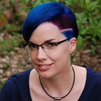 Head shot of Marieke Nijkamp wearing blue rimmed glasses and bright, blue hair