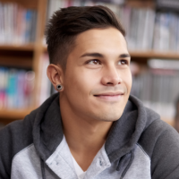 Adolescent Boy looks up from his book and notebook