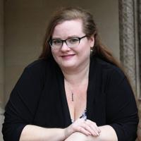 Head shot of Beth Revis wearing a black sweater and arms lightly crossed.